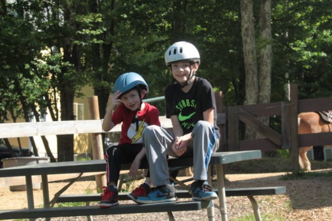 a young boy sitting on a bench in a park