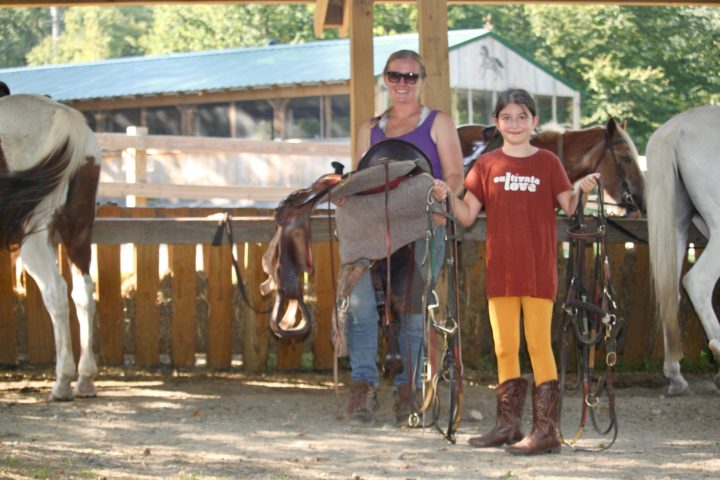 a group of people standing next to a horse