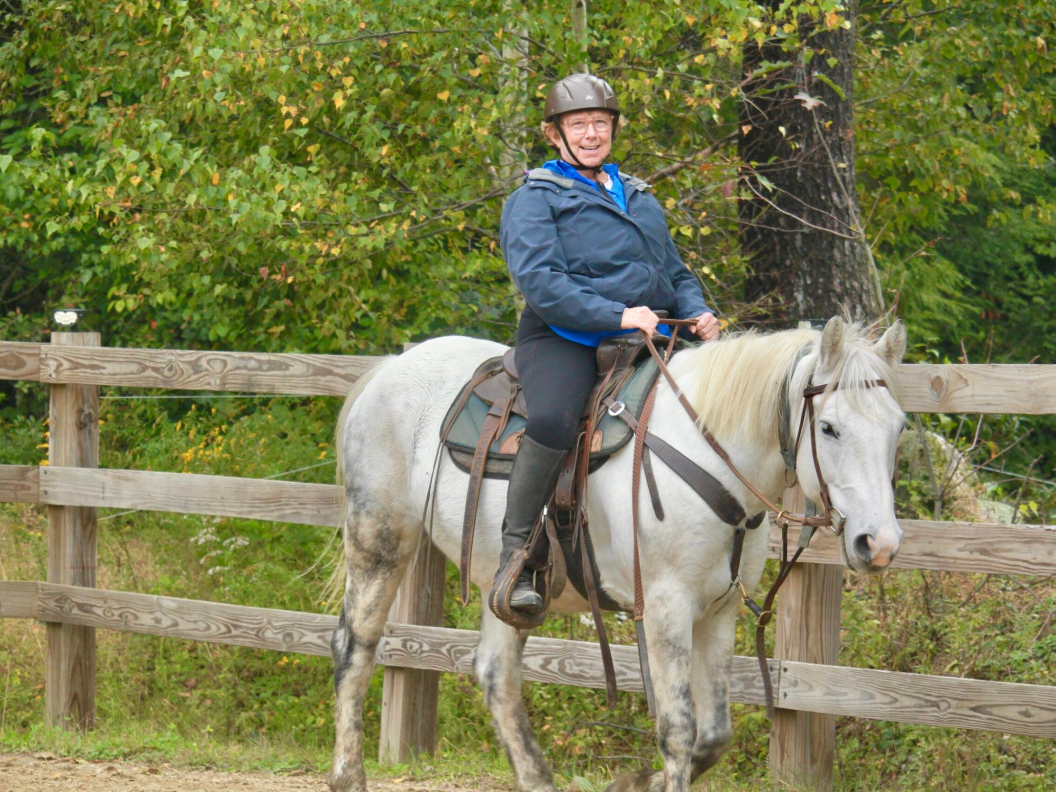 a women riding a grey horse