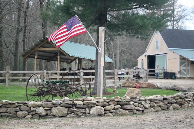 American flag on pole near stone cowboy